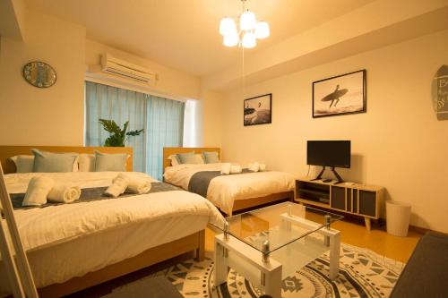 sypialnia z 2 łóżkami i telewizorem w obiekcie Roppongi Azabu Gorgeous Sea House w Tokio