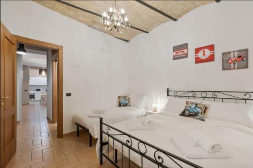 Roma Colosseum Apartment في روما: غرفة نوم بها سريرين وثريا