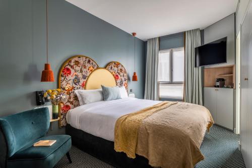 une chambre d'hôtel avec un lit et une chaise dans l'établissement Hôtel Léopold - Orso Hotels, à Paris