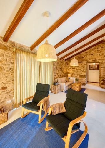 a living room with two chairs and a couch at Pedracuca - Costa da Morte in Neaño