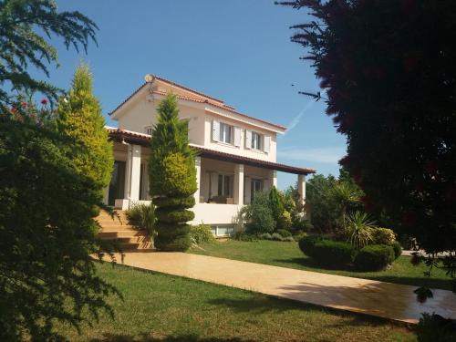 a white house with trees and a pathway at Beautiful Summer Villa in Chalkoutsi in Khalkoútsion