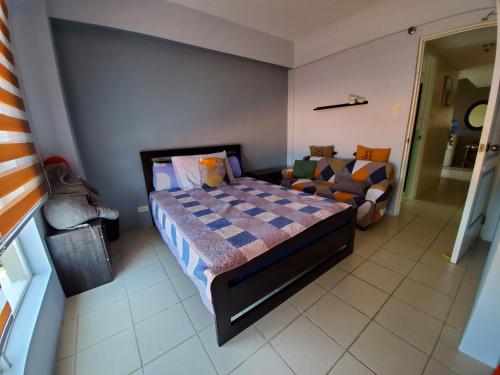 ein Schlafzimmer mit einem Bett und einem Sofa in der Unterkunft Presidio lakefront 2 bedroom staycation in Manila