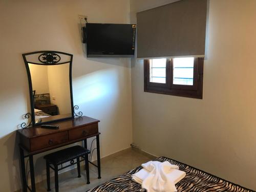 a bedroom with a dresser and a mirror and a bed at Traditional House Irina in Theologos