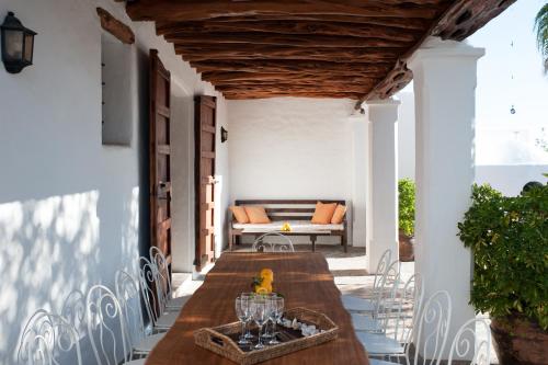 eine Außenterrasse mit einem Holztisch und Stühlen in der Unterkunft Can Tierra Roja in Santa Gertrudis