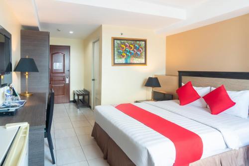 a hotel room with a large bed with red pillows at OYO 187 The Maxwell Hotel in Cebu City