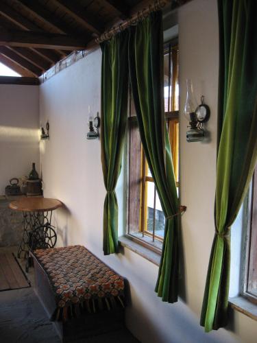 a room with green curtains and a bench in front of a window at Guest House Astra in Arbanasi