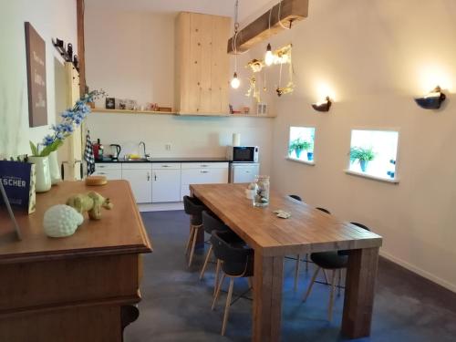 a kitchen with a wooden table and chairs at Altenburgpleats in Hempens