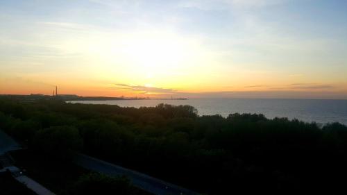 a sunset over the water with the sun in the sky at Vanilla Sky Apartments in Sillamäe