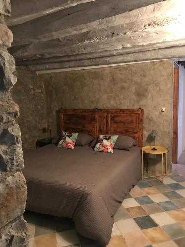a bedroom with a bed in a stone wall at Apartamento El Fenal de Turmo Casa rural "El Capricho de Nieves" in Laspuña