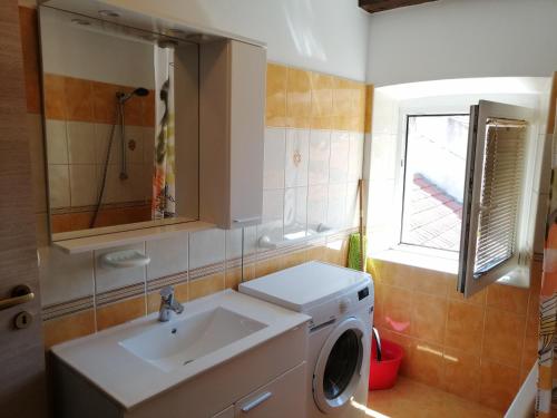 a bathroom with a sink and a washing machine at Apartments Ani in Vela Luka
