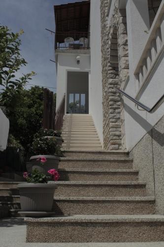 特羅吉爾的住宿－Apartments Renata，通往一座粉红色花朵的建筑的楼梯