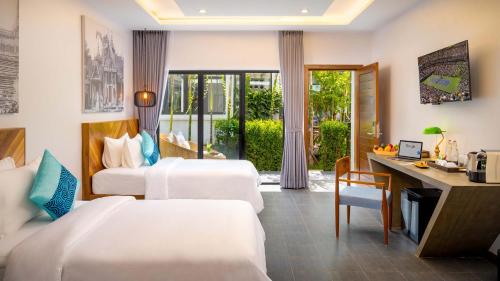 a hotel room with two beds and a desk at Grand Venus La Residence in Siem Reap