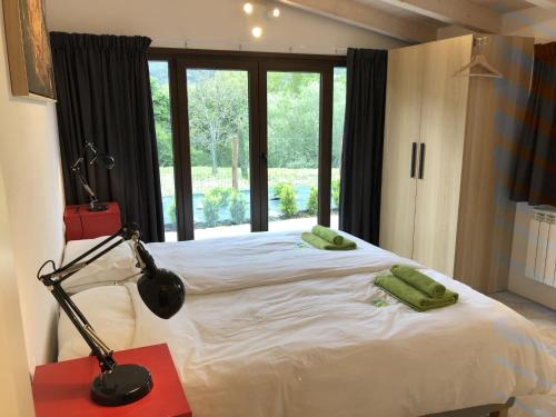 una camera da letto con un letto con una lampada e una finestra di Luxurious Holiday Home in Bagni di Lucca with Pool a Bagni di Lucca