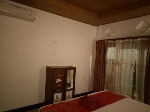 a bedroom with a bed and a dresser and a window at Swara Homestay 2 in Nusa Lembongan