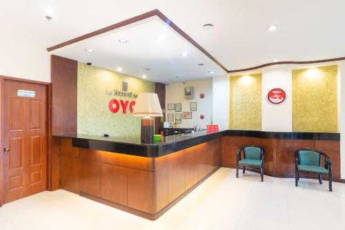 a lobby with a waiting area with two chairs at OYO 187 The Maxwell Hotel in Cebu City