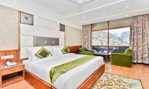 a hotel room with a bed and a window at Hotel Snowcrests Manor in Manāli