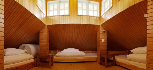 two twin beds in a room with a window at Alėjos Namelis in Palanga