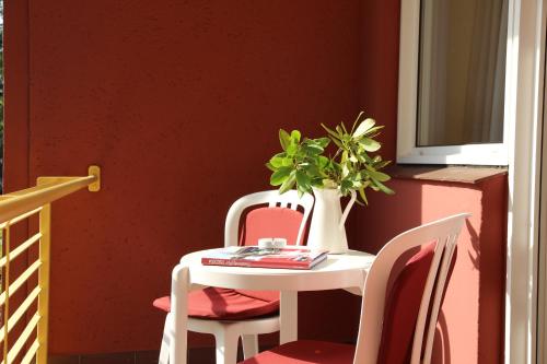 a table with two chairs and a vase with a plant at Hotel Wald und See in Heringsdorf