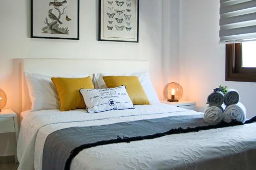 - une chambre avec un lit doté d'oreillers jaunes et blancs dans l'établissement Phaedrus Living Seaview Luxury Flat Lighthouse 53, à Paphos
