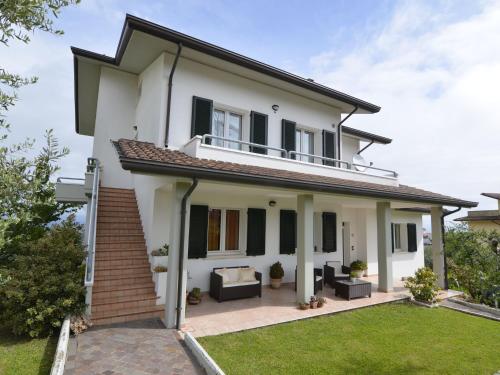ein weißes Haus mit einem Balkon und einer Liegewiese in der Unterkunft Belvilla by OYO Casa Cevoli in Gemmano