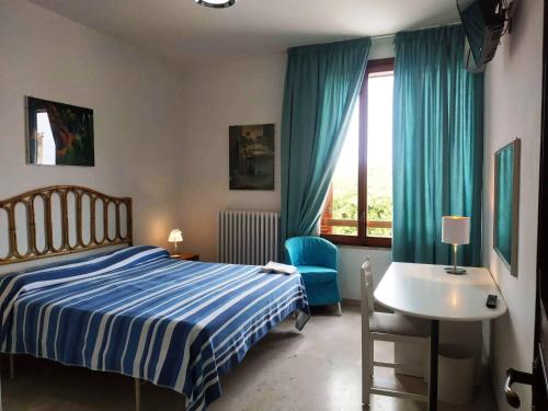 Un dormitorio con una cama y una mesa y una ventana. en Porta Alfonsina, en Otranto