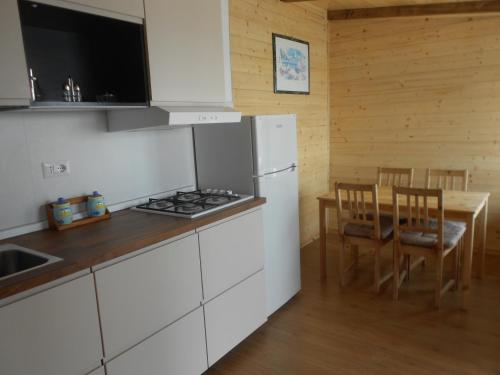 a kitchen with a white refrigerator and a table with chairs at Il Rospo in Moneglia