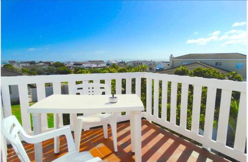 a white table and chairs on a white balcony at Au Plais De Langebaan at Palm Tree Villa in Langebaan