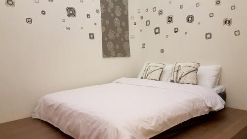 una camera con un letto bianco e una parete con immagini di Fishmoon homestay a Magong