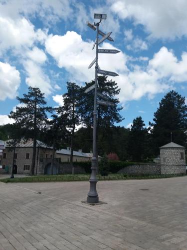 a pole with street signs on it in a parking lot at Apartments Mirković in Cetinje