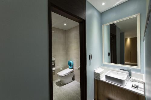 a bathroom with a toilet and a sink and a mirror at Notte La Mia Hotel in Busan