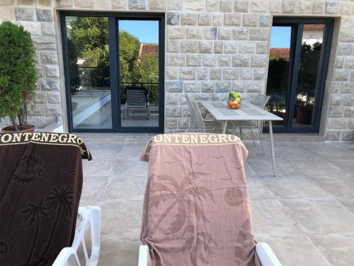 a patio with two chairs and a table on a patio at Apartments Bane in Herceg-Novi
