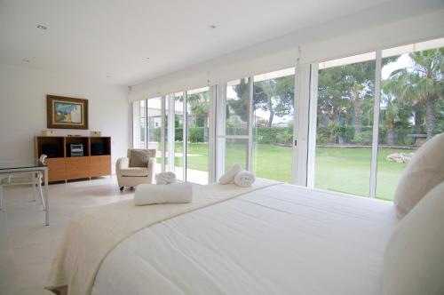 シッチェスにあるLuxury Beach Houseの白い大きなベッドルーム(大型ベッド1台、窓付)が備わります。