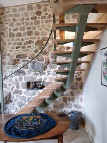a staircase in a house with a stone wall at Les Fayettes in Montregard