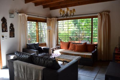 sala de estar con sofá, sillas y ventana en La Ventarrón en Mar de las Pampas