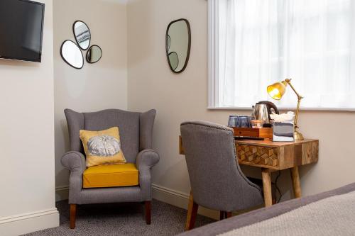 a bedroom with a desk and a chair and a bed at The Old Cock Inn in Harpenden