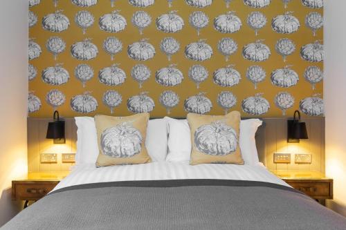 a bedroom with a bed with a black and white wallpaper at The Old Cock Inn in Harpenden