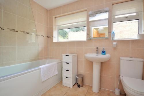 uma casa de banho com um lavatório, uma banheira e um WC. em Solent View em Seaview