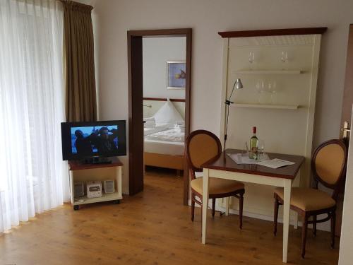 ヴェスターラントにあるSylter-Besserburg-App-8のリビングルーム(テレビ、テーブル、椅子付)