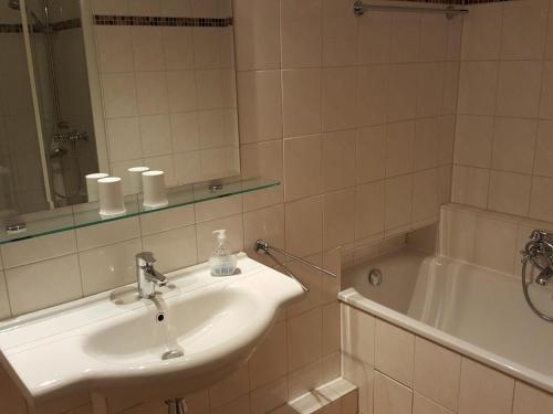 ein Badezimmer mit Waschbecken und Badewanne in der Unterkunft Sylter Besserburg App. 2P in Westerland