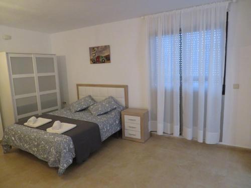 una camera da letto con un letto, una sedia e una finestra di Apartamento Mil Palmeras a Pilar de la Horadada