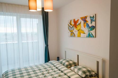 a bedroom with a bed and a window with a painting at Paul's place. New rooftop apartment in Downtown Sibiu in Sibiu