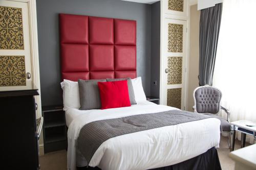a bedroom with a large bed with a red headboard at Bosanneth in Falmouth