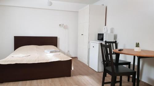 a bedroom with a bed and a table and a microwave at SAULES SVECIU NAMAI in Palanga