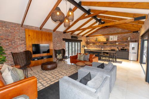 an open living room with a couch and a kitchen at Kransplaas - Nyala Lodge in Graaff-Reinet