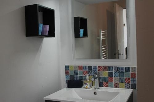 a bathroom with a sink and a mirror at Le secret d'Oscar & la fantaisie de Jean in Morlaix