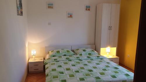 a bedroom with a bed and two lamps on night stands at Apartments and Rooms Dobrila in Jelsa