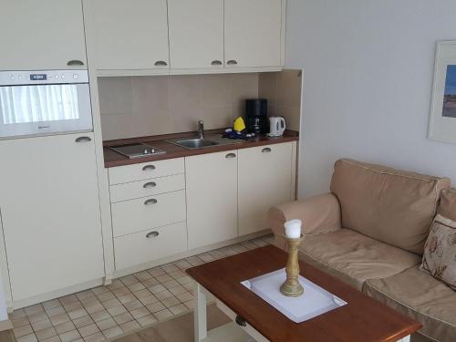 salon z kanapą i kuchnią w obiekcie Sylter-Besserburg-App-16 w mieście Westerland