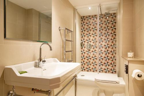 a bathroom with a sink and a toilet and a shower at The Old Cock Inn in Harpenden