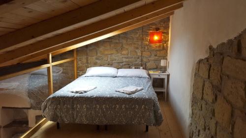 a bedroom with a bed in a stone wall at Casa delle Stelle in Castelmezzano