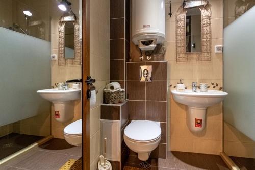 ein Badezimmer mit zwei Waschbecken und einem WC in der Unterkunft Soulful Apartments in Warna